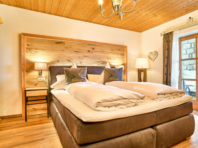 Schlafzimmer mit Boxspringbett in der Chalet-Wohnung Arbersee in Bodenmais