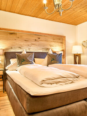 Schlafzimmer mit Boxspringbett in der Chalet-Wohnung Arbersee in Bodenmais
